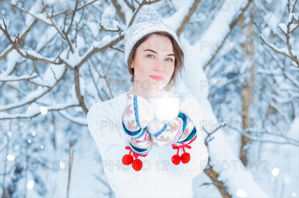 Portrait of a beautiful woman holding a cup of tea in her hands. Concept of Christmas
