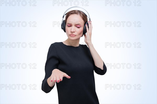 Portrait of a woman in professional headphones. White background. Dj concept.