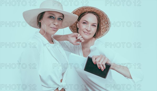 Portrait of two smiling women with passports and boarding passes in their hands. Travel concept.