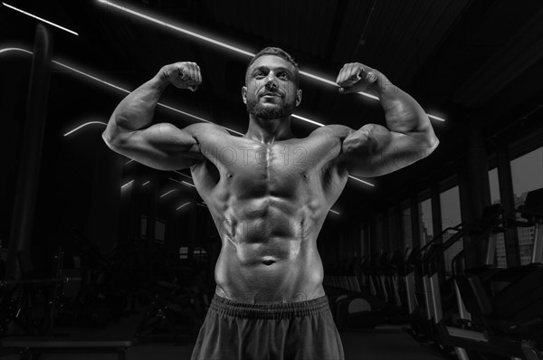 Image of a muscular guy with a naked torso and abs. Gym. Fitness concept