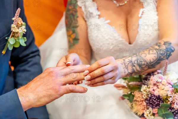 A very happy bride putting the ring on the groom at a wedding