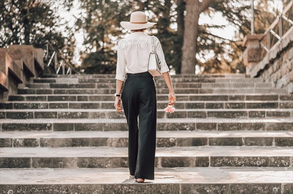 Portrait of a charming girl climbing the stairs to Piazzale Michelangelo in Florence. The concept of tourism