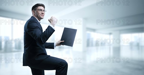 Man with a tablet in his hand screams with joy in the office. The concept of achieving success in business.