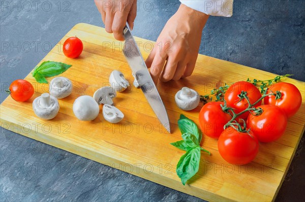 Professional chef cuts vegetables with a sharp knife from Damascus steel.