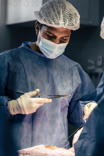 A Latin surgeon is depicted performing a surgery in the operating room. Hospital and operating room