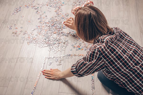 Teenager plays puzzles. The concept of board educational games. Stay at home.