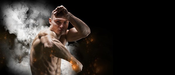 Professional boxer posing in the studio. He stands in front of the camera and elbows. The concept of sport