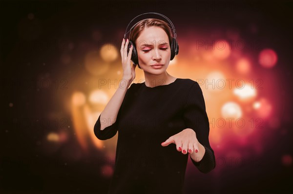 Image of a girl in a black dress with headphones in a nightclub. Party concept.