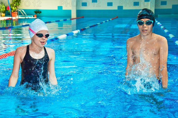 The swimming coach shows exercises for children in the pool