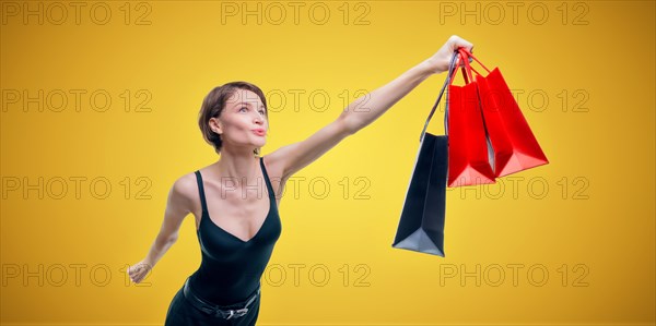 Portrait of a beautiful woman with packages. She enthusiastically rushes shopping. Shopaholic concept. Shopping centers. Sales.