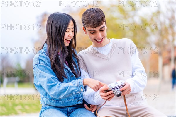 Young people looking photos at the screen of a digital camera