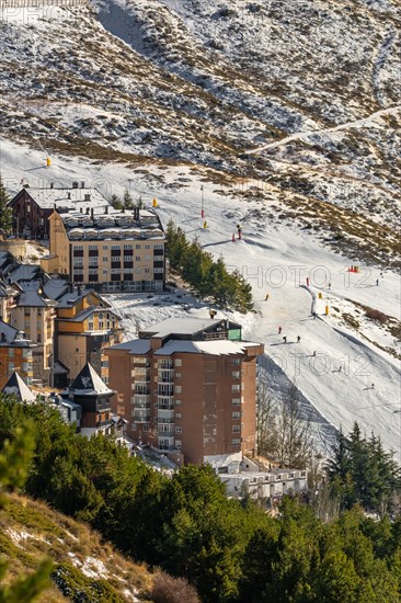 Aerial view of ski resort hotels and slopes with skiers