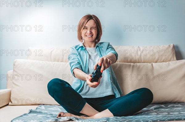 Girl with a joystick in her hands enthusiastically plays a computer game. ESports concept.