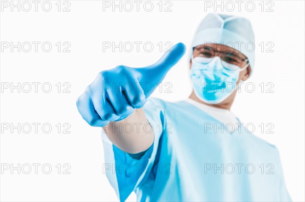 The doctor shows a raised finger up on a white background. Medicine concept.