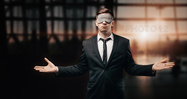 Portrait of a man in a mask for sleeping. He stands in the airport terminal and spreads his hands in disbelief. The concept of travel