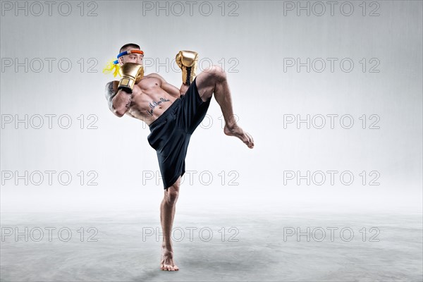 Portrait of a Thai boxer. He hits with his knee. Competitions and tournaments concept.