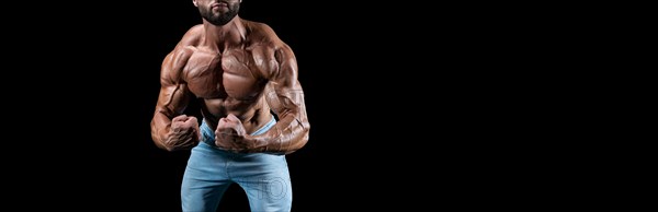 No name sexy muscular man in jeans posing on black background. Bodybuilding and fitness concept.