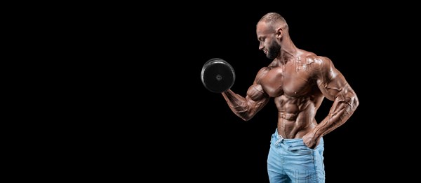 Isolated muscular man on a black background. Bodybuilding and fitness concept. Panorama.