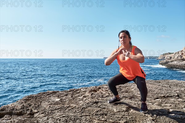 FITNESS WOMAN IN SPORTS SET TRAINING WITH ELASTIC BAND