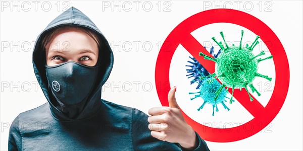 Portrait of a girl in a protective mask who shows up her finger against the background of the stop viruses sign.