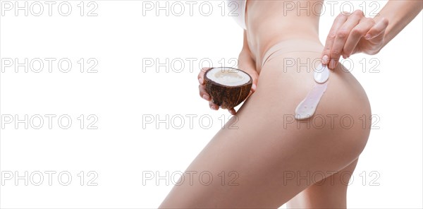 Image of female hands applying natural coconut cream to the buttocks. Medical concept. Anti-cellulite ointments.