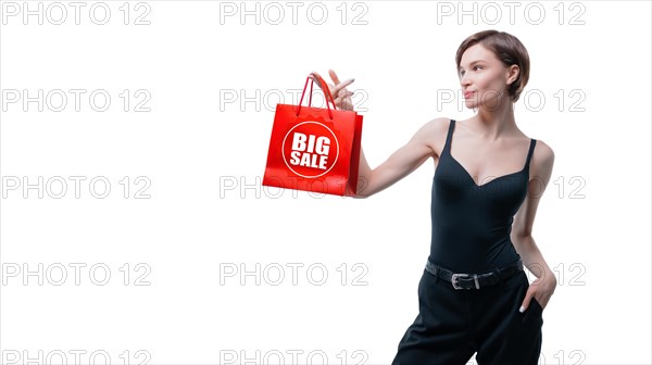 Beautiful young woman holding a craft red package in her hand. Shopaholics concept. Spenting. Gifts for the holidays. Black Friday. Shopping centers