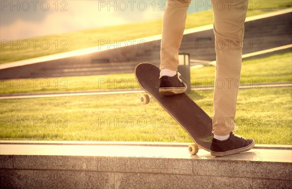 Desperate skateboarder performs dangerous movement on the skateboard at sunset