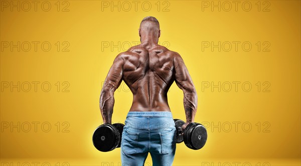 Isolated professional sportsman on a yellow background. Bodybuilding concept. Panorama. Advertising of a gym and sports nutrition.