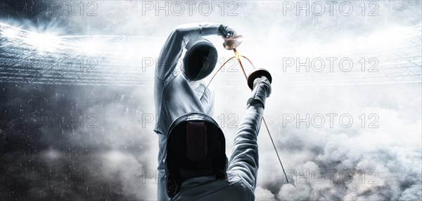 Portrait of two fencers against the backdrop of a sports arena. The concept of fencing. Duel.