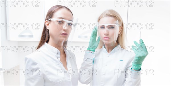 Portrait of two girls in white coats. The concept of cosmetology