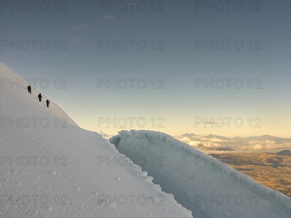 Climber above a crevasse on the steep glacier of the Cayambe volcano