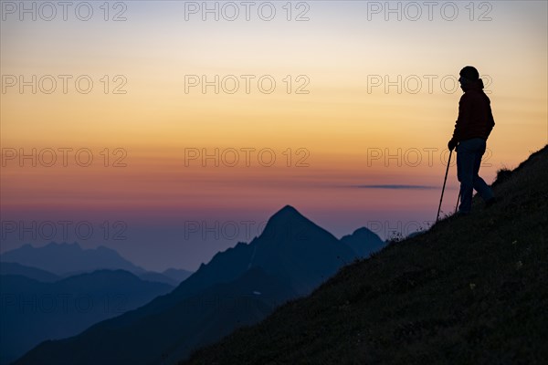 Mountaineer on mountain ridge with Rothorn peak in the background at blue hour