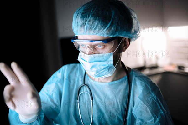 Male scientist doctor working in a laboratory with a monitor in a sterile uniform and glasses