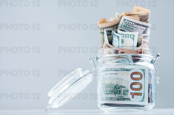 Glass jar full of money. Crisis Savings Concept.