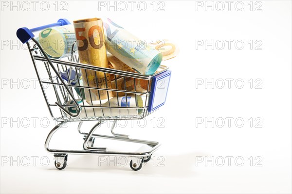 Shopping cart full of rolled up euro banknotes