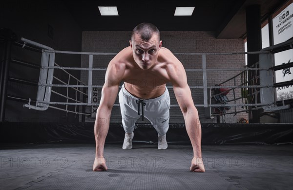 Muscular man doing push-ups in the gym. Fitness concept.