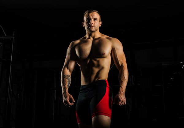 Portrait of a weightlifter who poses without a shirt. Front view