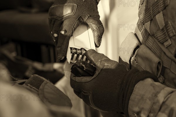 The fighter prepares a clip with bullets before the next fight.