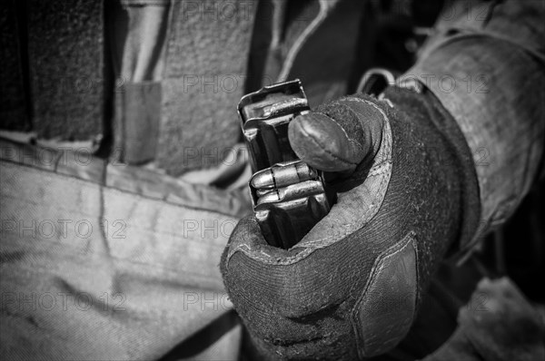 The fighter prepares a clip with bullets before the next fight.