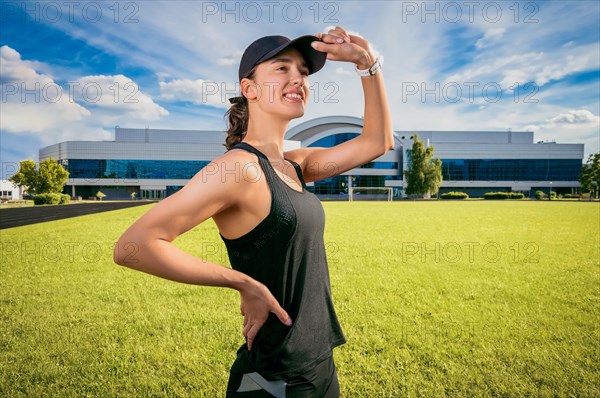 Image of a smiling girl standing on a soccer field. Sports concept.