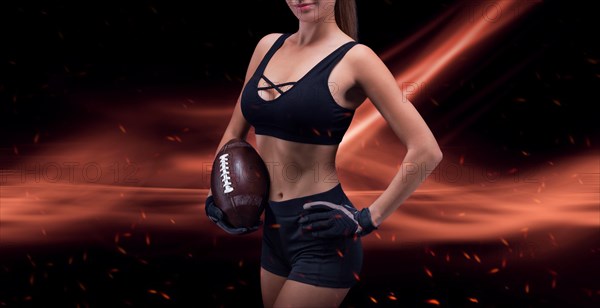 Portrait of a sportive girl in the uniform of an American football team player. Sports concept. Futuristic background.