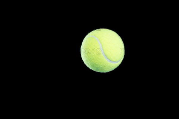 Image of a tennis ball on a black background. Sports concept.