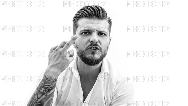 Stylish bearded man shows middle finger to the camera. The concept of failure