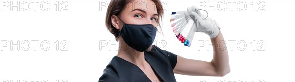 Portrait of an elegant beautiful girl wearing a protective mask with a set of nail palette in hand. White background. Advertising banner for beauty salons during Covid-19. Pandemic. Modern trends