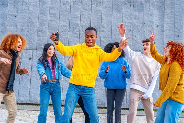 African man with a stereo dancing with friends in the street