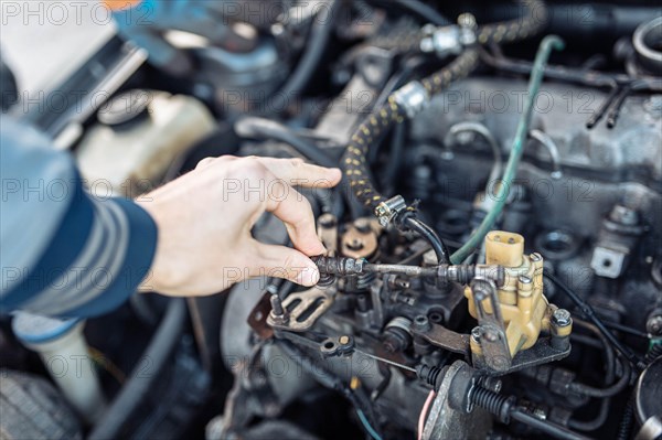 Auto mechanic regulates fuel supply with throttle cable lever