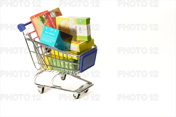Shopping cart full of boxes of grocery items isolated on a white background
