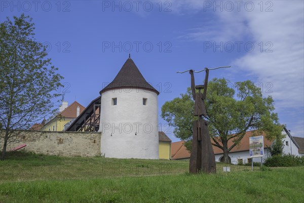 Tower of the fortified village and wooden sculpture