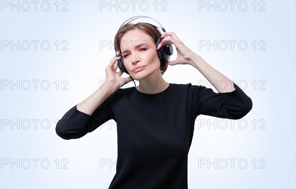 Portrait of a woman in professional headphones. White background. Dj concept.