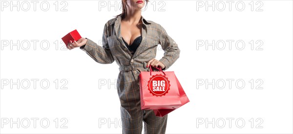 Charming brunette in glasses posing in the studio with red bags and a box for jewelry. White background. Shopping concept.